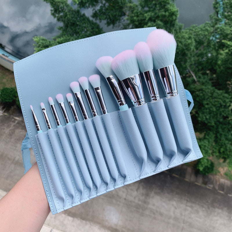 A set of 12 light blue wooden-handle makeup brushes, including small rainbow makeup brushes, powder brushes and eye brushes, as makeup tools.